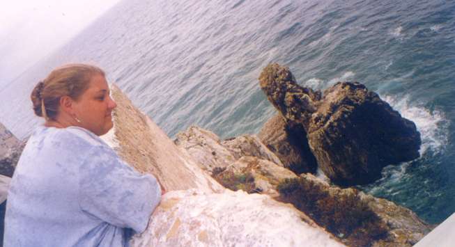 Claudia Braun an der Mauerbrstung der fortaleza (Festung) von Sagres, die als vorgeschobene Landzunge in den wogenden Atlantik hinausreicht.