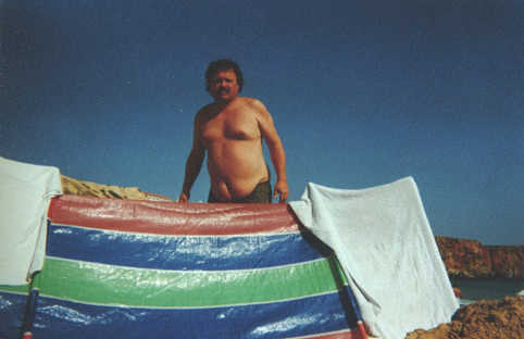 Ingo Trautwein mit seinem Sonnensegel an einem Strand bei Sagres.